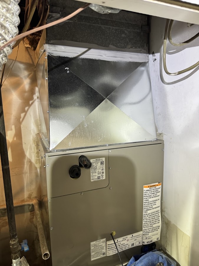 Sheet metal duct connection above an indoor HVAC unit